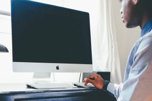 A man sits in front of a computer.